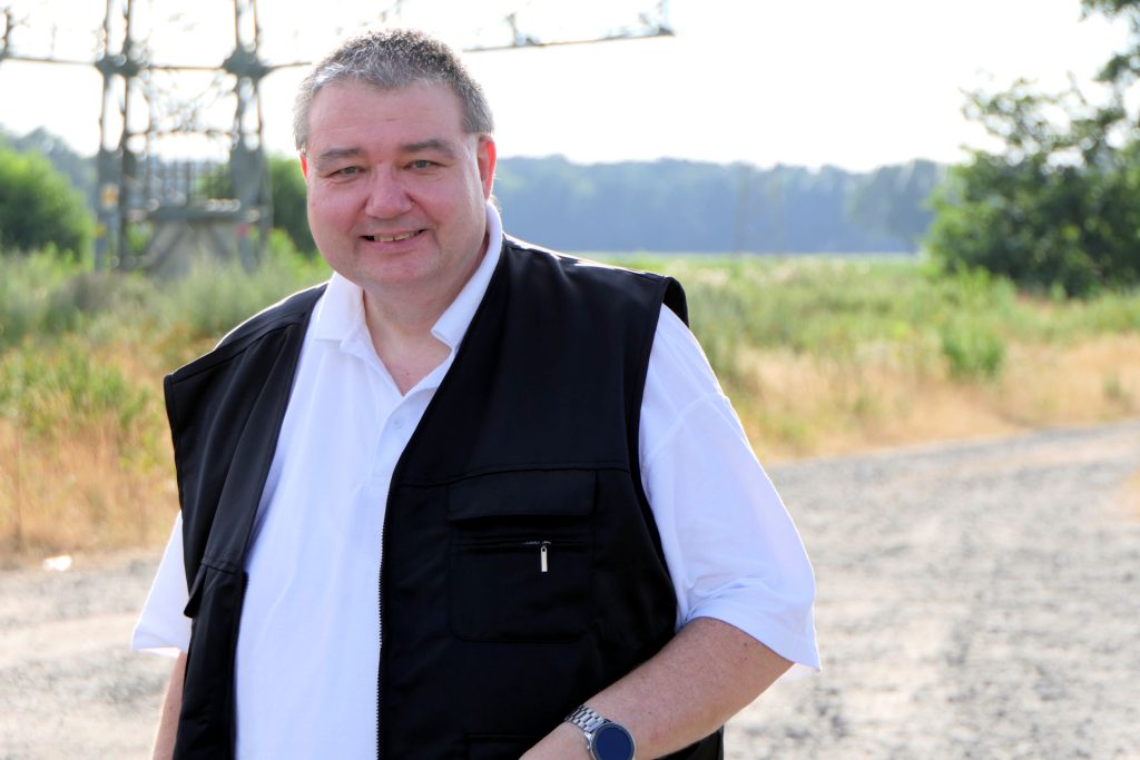 Holger Pellmann im Gewerbegebiet "Schwarzer See" vor einem Strommast.